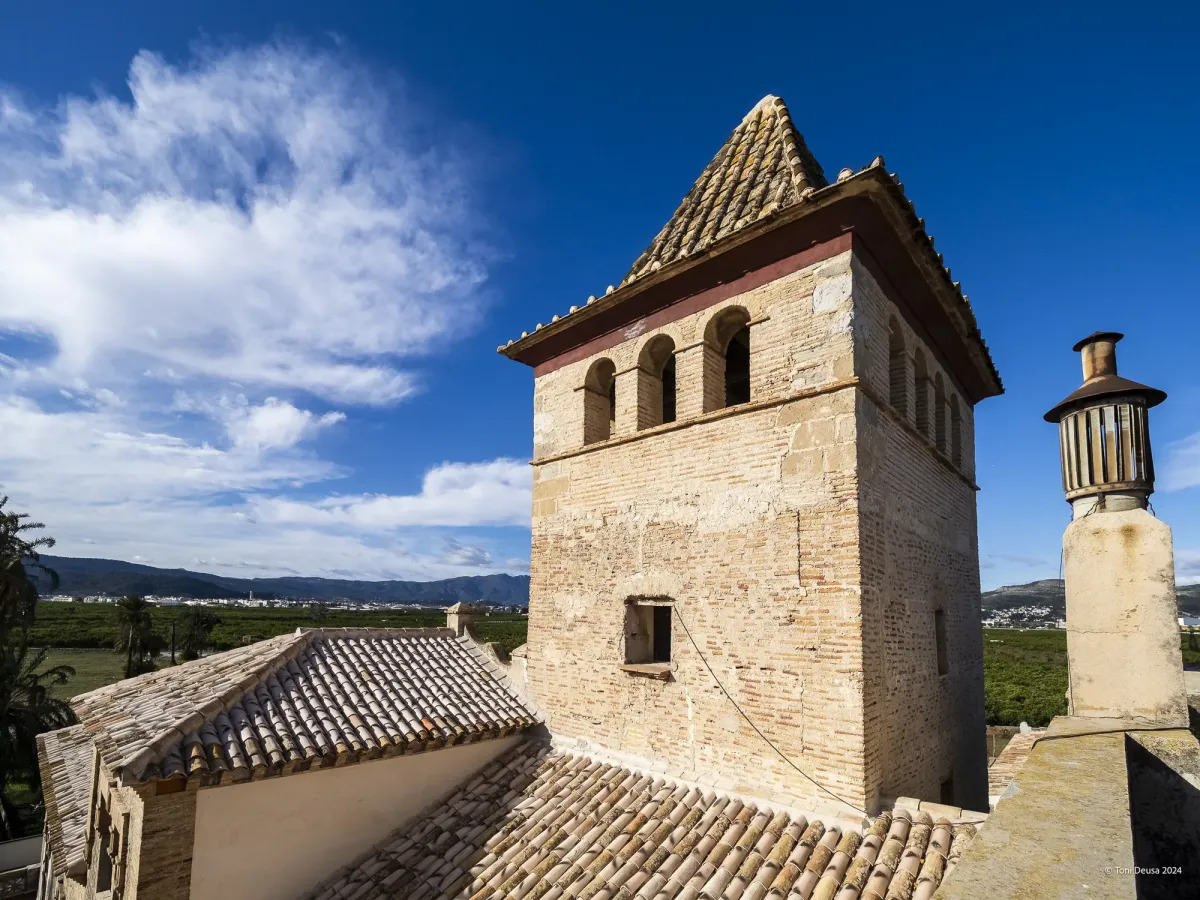 Cubiertas de la alquería y torreón de la Torre dels Pares con la huerta de naranjos y las montañas de la Safor al fondo