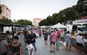 Visitantes entre los puestos del mercado de los domingos en Gandia
